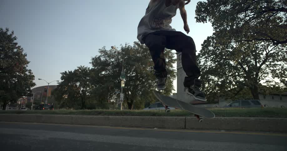 Man does a skateboard jump in a park on a sunny day