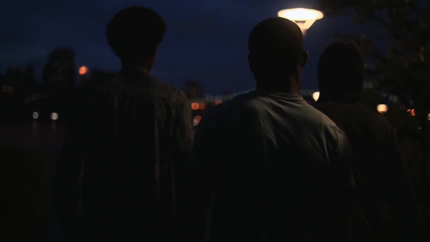 Young men walking down the street in an urban area next to the water
