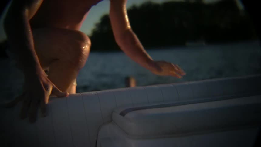 A swimmer climbs into a boat
