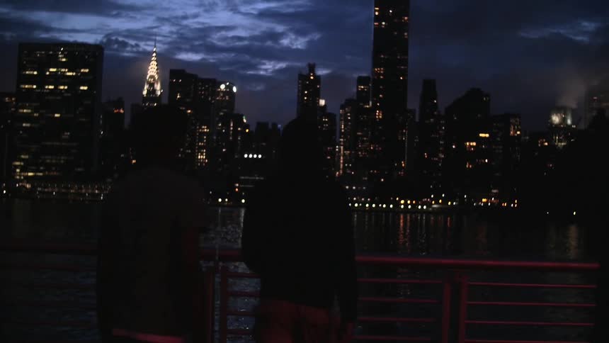 A group of boys look towards a city at night
