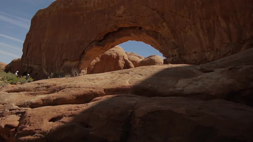 A large rock formation looms overhead in the desert