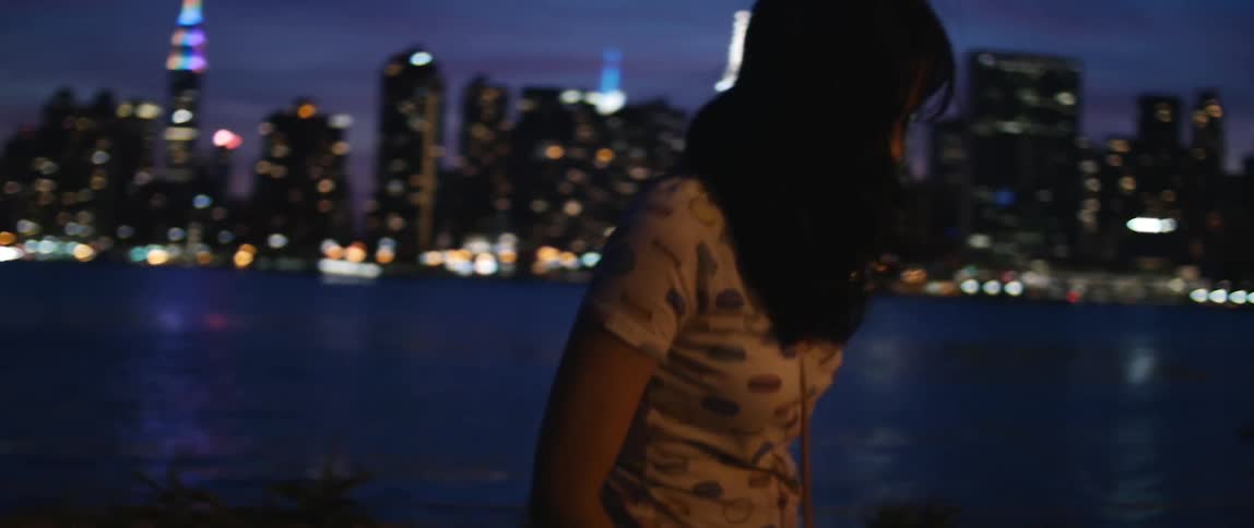 A woman looks at the skyline at night