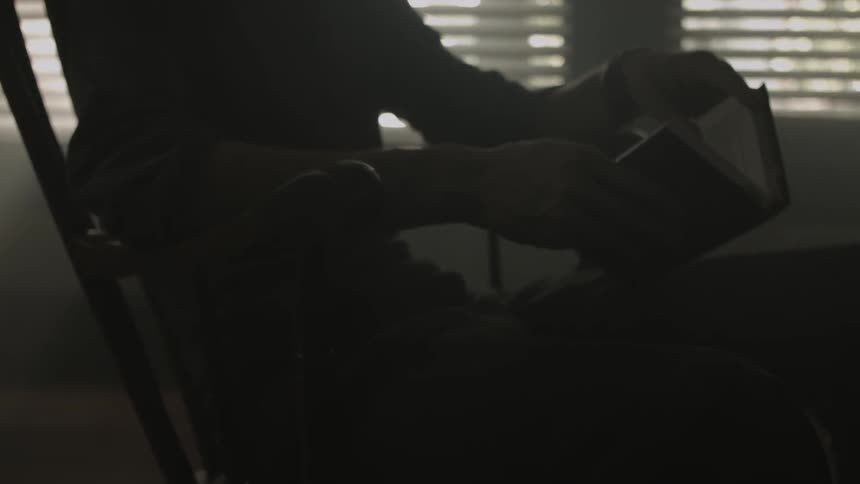 A person sits in a chair and reads a book