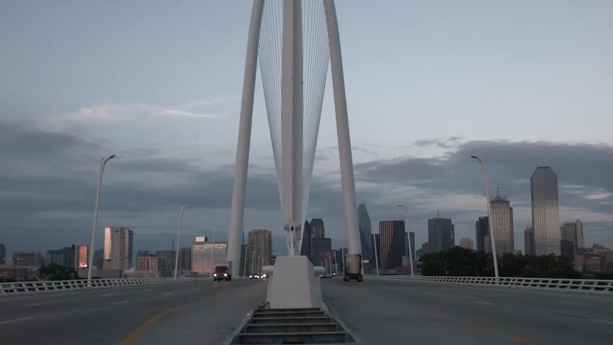 Middle of a bridge overpass leading to a big city