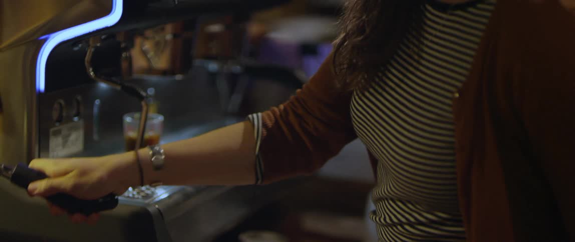 Woman pours drink from machine then smiles