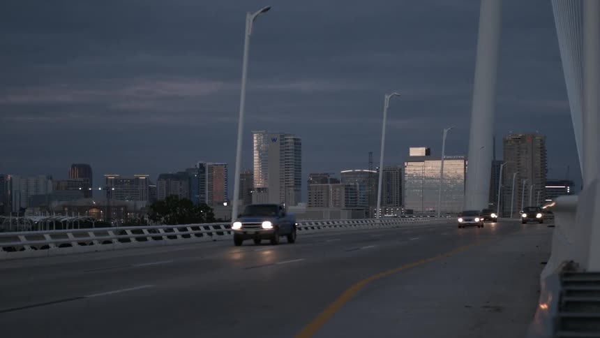 Sunset view of a road with cars leaving a city