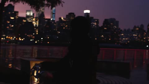 Person sitting on a bike at night time by the water