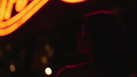 Person standing outside looking around at night