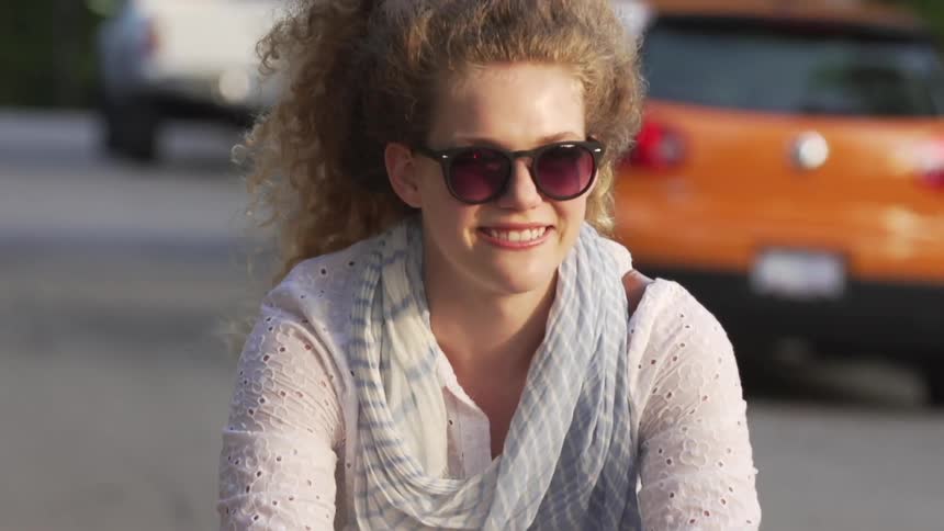 Woman smiling as she rides her bike on a sunny day