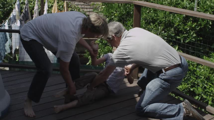 Two men restrain a young girl who tried to climb over a balcony ledge