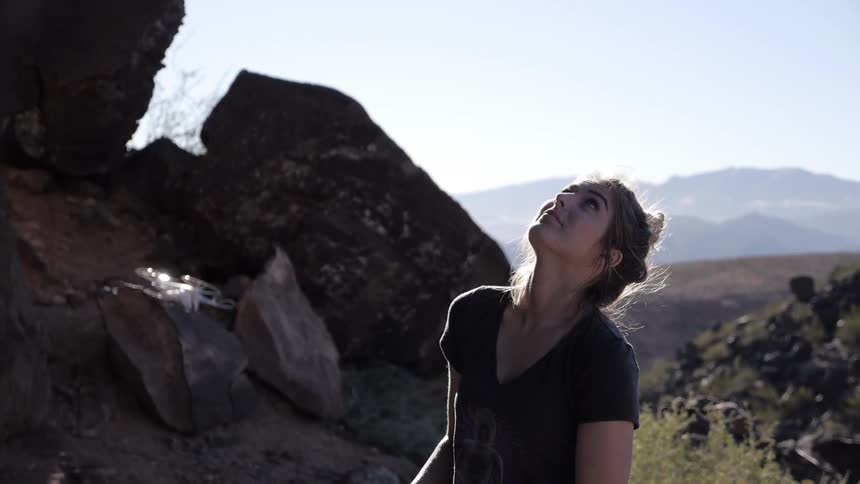 A woman gazes around nature on a sunny day