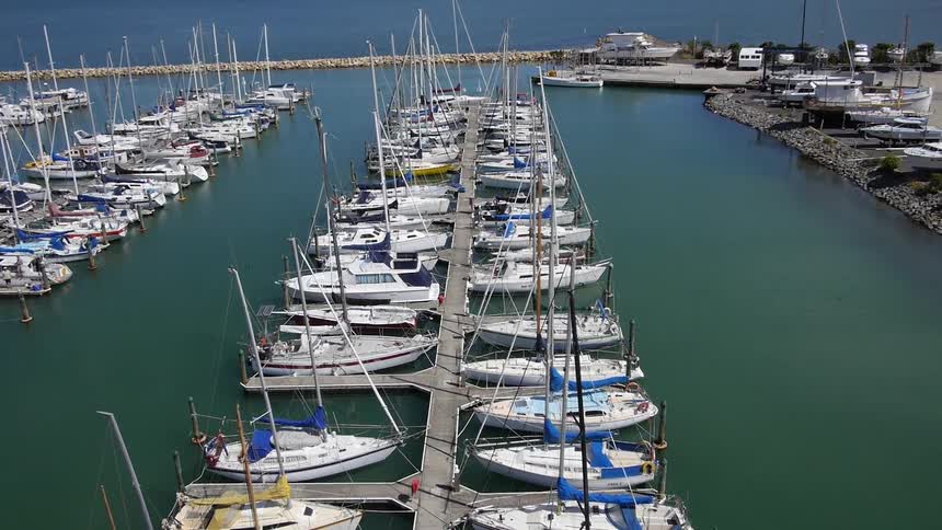 Sailboats are docked in a calm marina