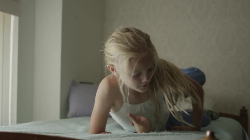Blonde girl climbs onto the bunk bed