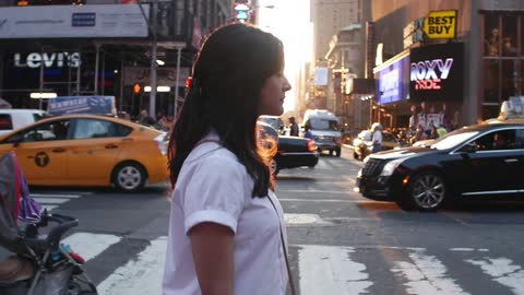 Woman walking across a busy street on a sunny day