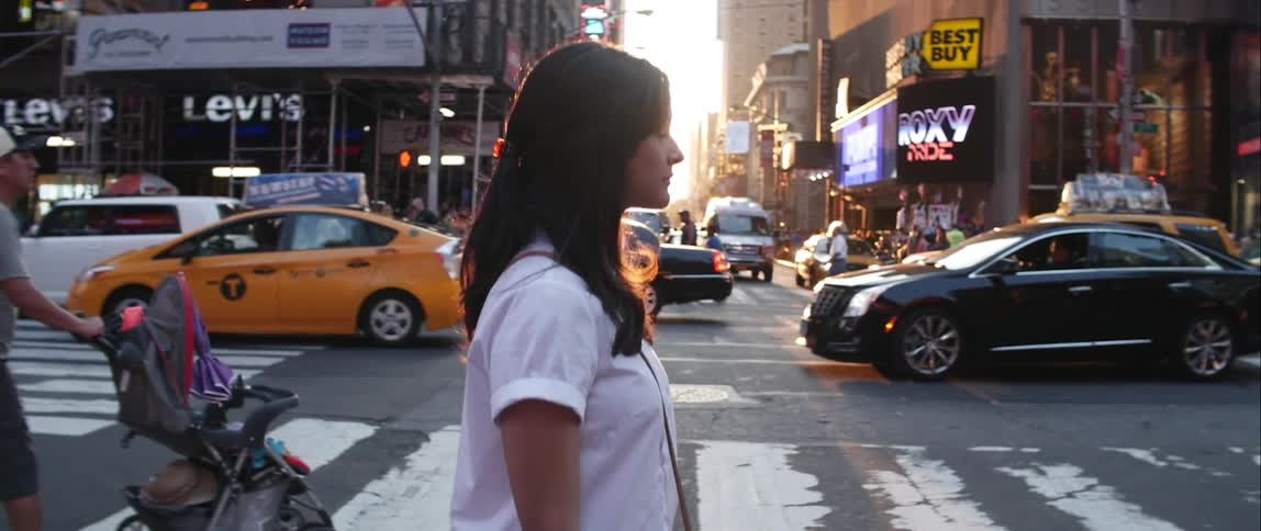 Woman walking across a busy street on a sunny day