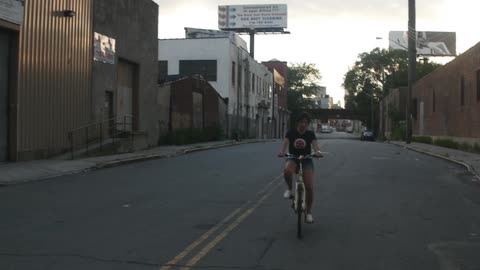 Woman rides her bike down an empty street