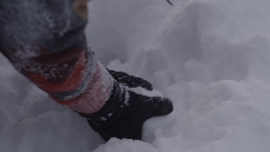 Woman picks up snow and makes a snowball