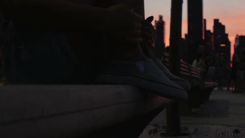 A person sits on a city bench at dusk