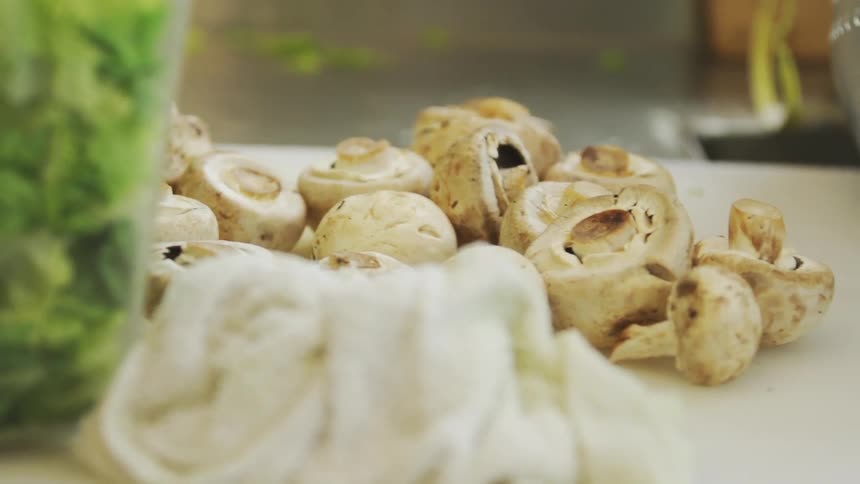Mushrooms sit on a cutting board on a counter