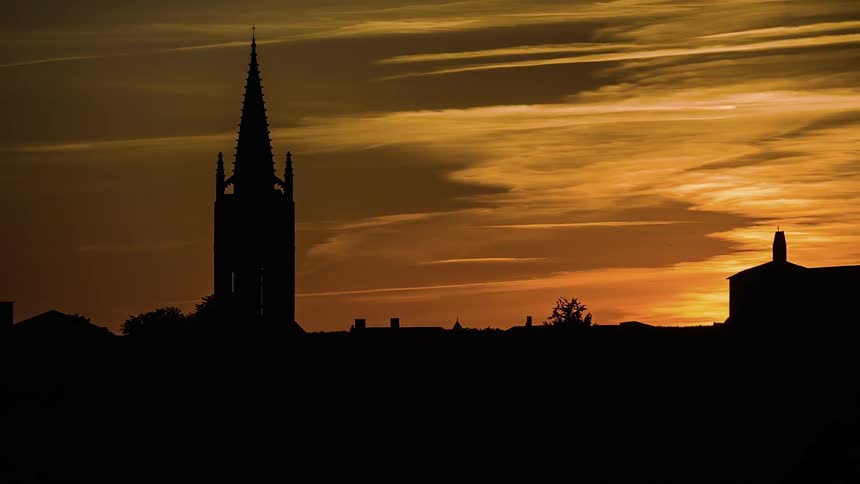Sun setting on a cloudy town
