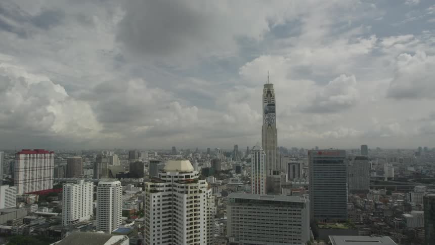City buildings and skyscrapers stand against a cloudy sky