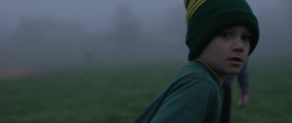 Boys play on a foggy field