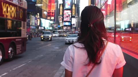 Woman walking down the sidewalk in a large city