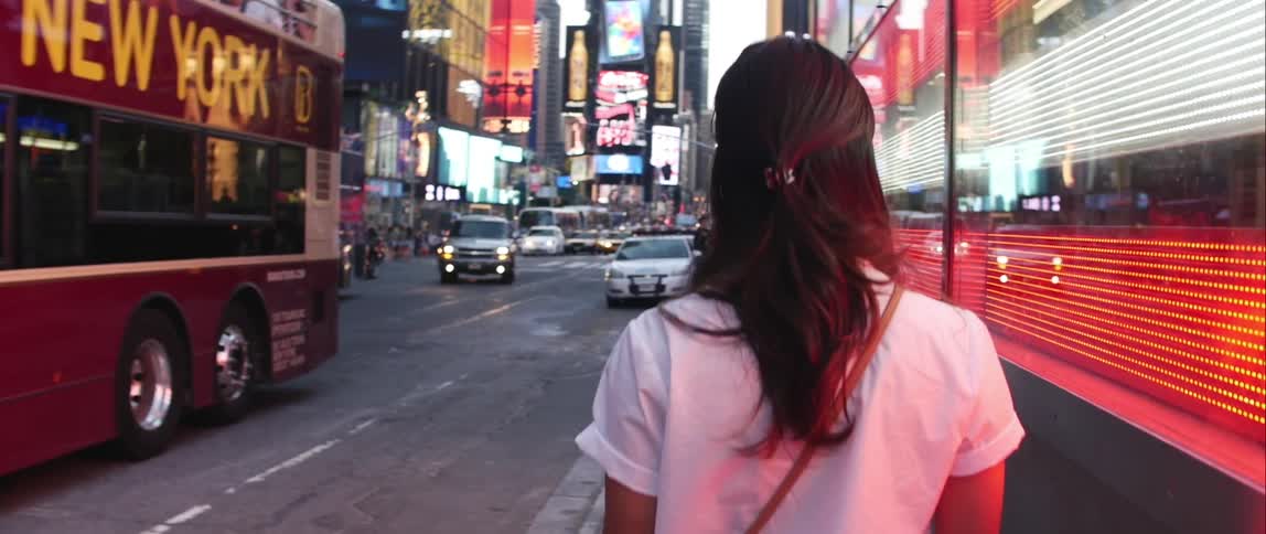 Woman walking down the sidewalk in a large city