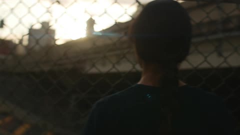A person standing in front of a fence