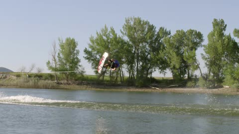 A man does a trick on a wakeboard