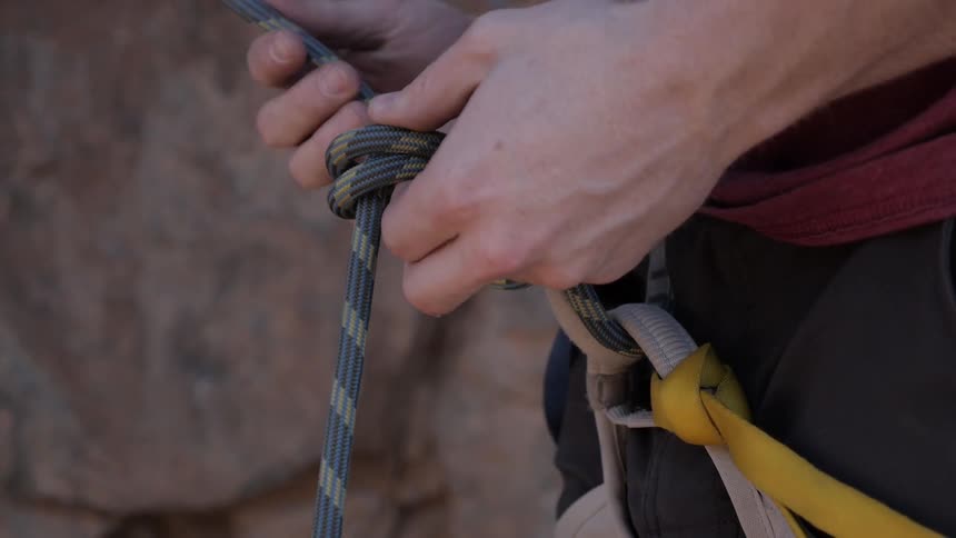 Man tying a rope in his harness