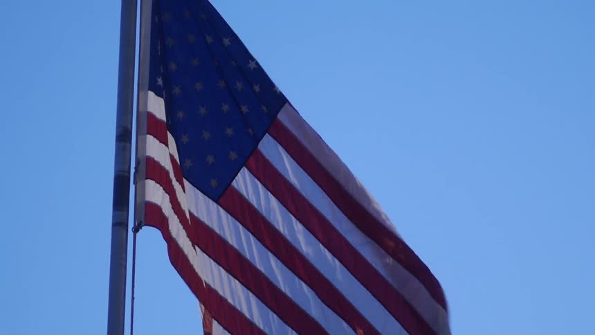 A flag waving in the wind on a clear day