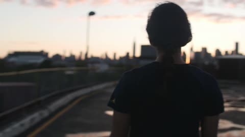 Woman walking in a parking lot at sunrise