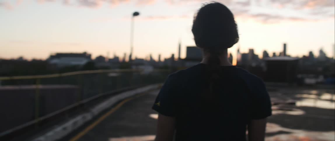 Woman walking in a parking lot at sunrise