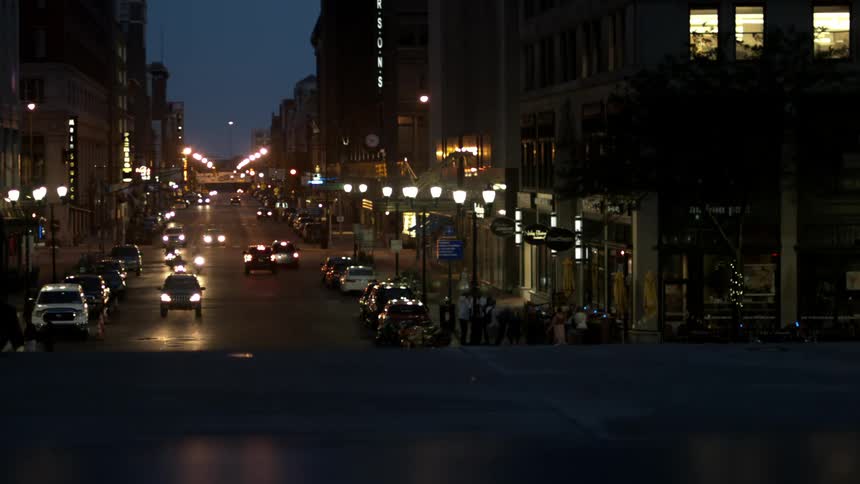 City at night with cars driving and people walking
