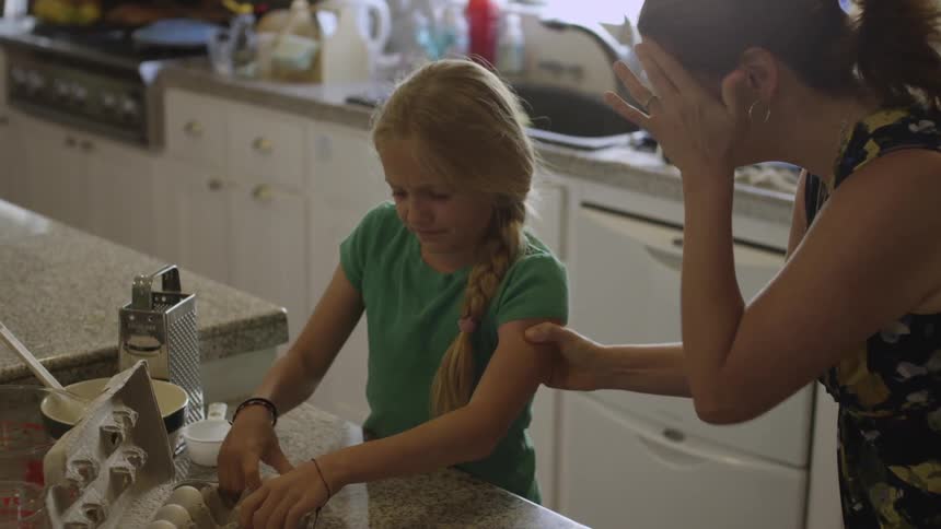 A woman dragging a girl from a sink then the girl slams eggs on a counter