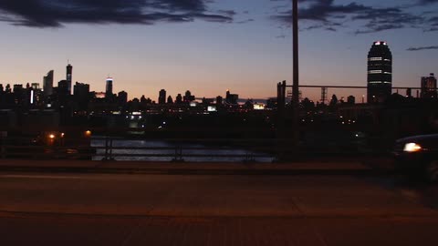 View of a city skyline at dusk from a busy freeway