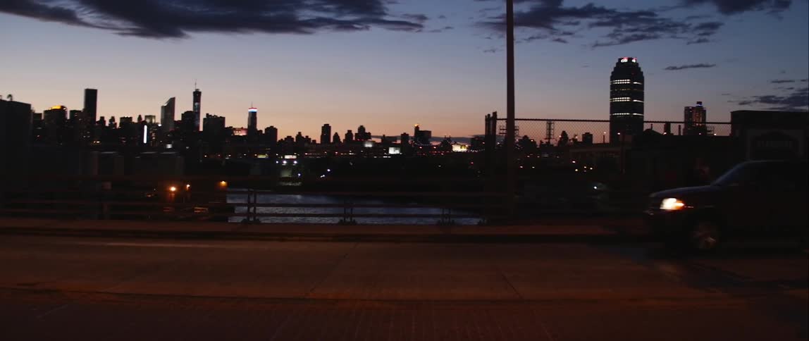 View of a city skyline at dusk from a busy freeway