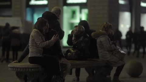 People sitting down and talking near a building