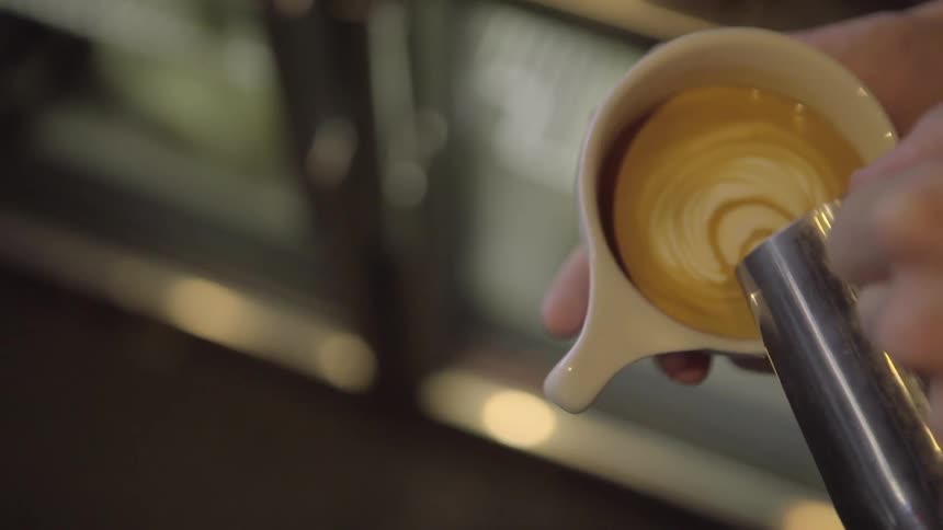 Hands pouring a latte