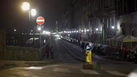 Night time view of a city block with cars passing in front