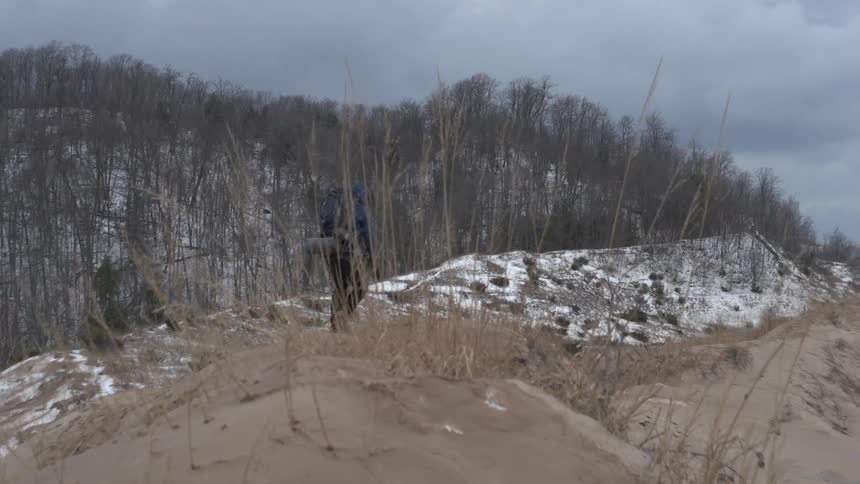 A hiker walks in a snowy area
