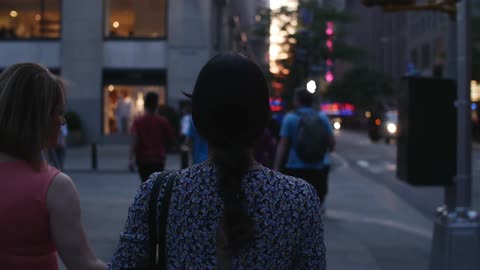 People walking down a busy city street at sunset