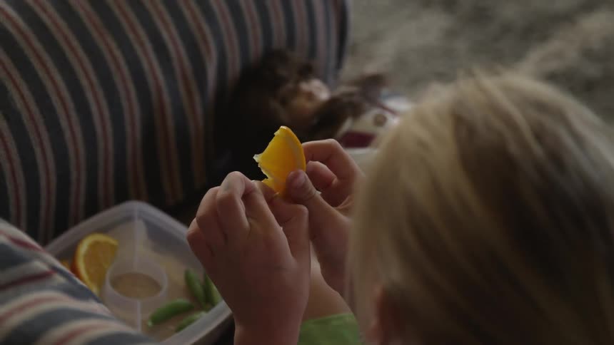 Girl picking seeds out of an orange slice