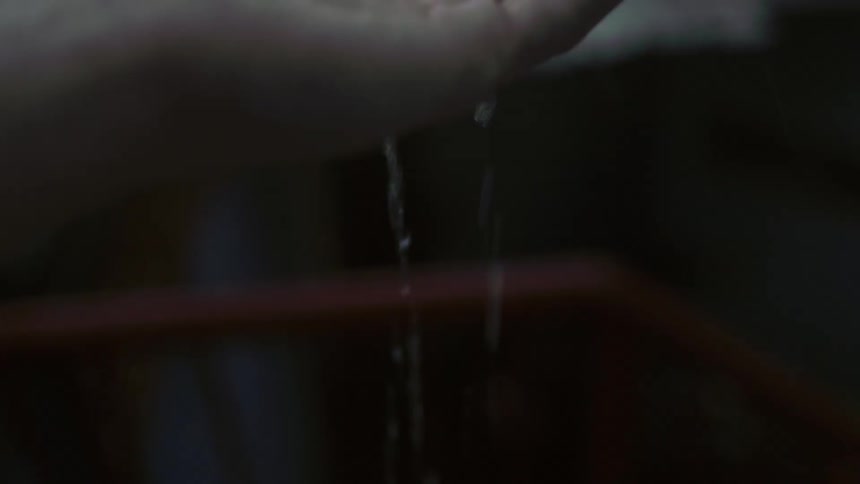 Hand outstretched as water pours on it