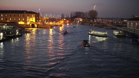 Boats traveling down a small body of water at sunset