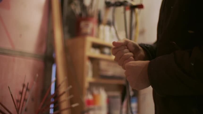 A man opens a tube of paint