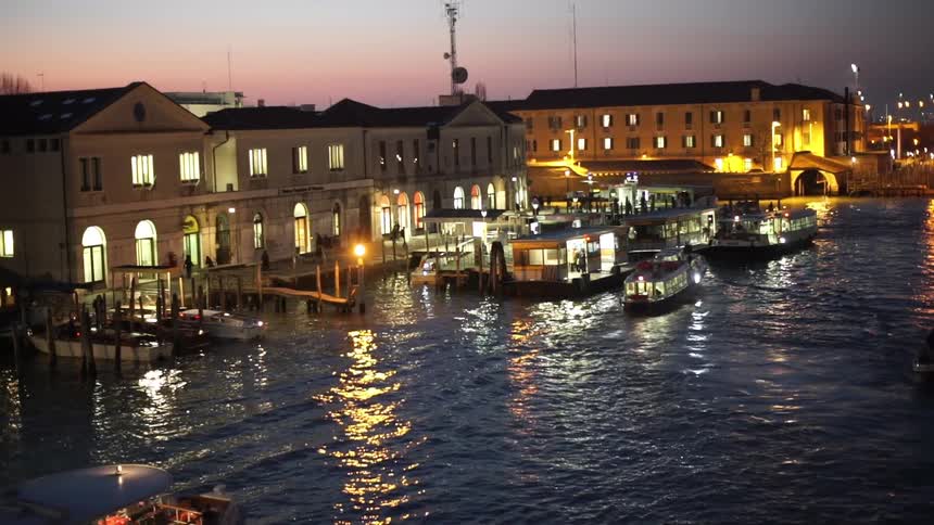 View of buildings right on the waterfront with boats docked at sunset