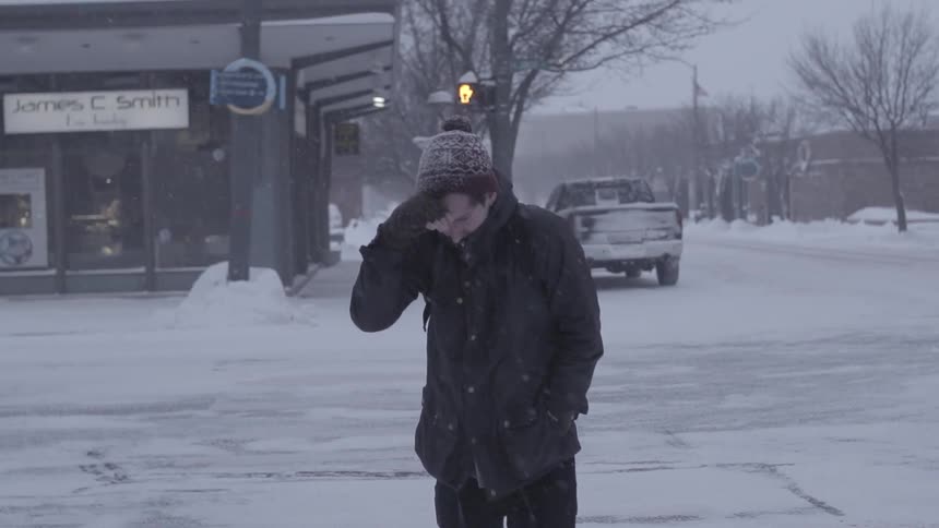 Man walking in the snow in in town