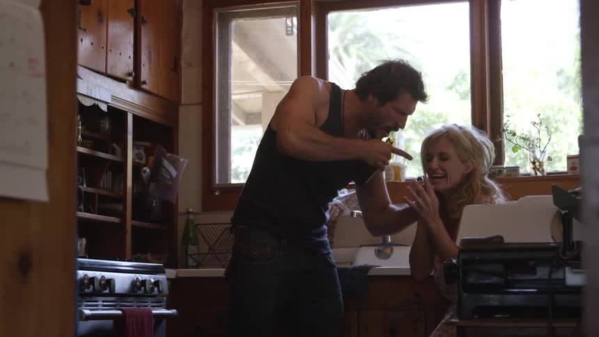 A woman fights with a drunk abusive man in their kitchen
